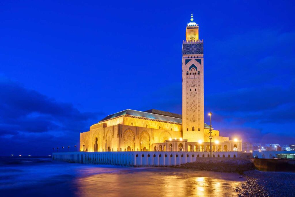Scopri la Moschea Hassan II di Casablanca durante il tour di Capodanno in Marocco con partenza da Catania La foto mostra la spettacolare Moschea Hassan II di Casablanca, illuminata durante le ore serali. Situata sul mare, è una delle moschee più grandi del mondo e rappresenta una delle tappe principali del tour di Capodanno in Marocco organizzato da Seinvacanza, con partenza da Catania e guida in italiano. Un’immagine che racchiude l’essenza del viaggio: cultura, architettura e fascino senza tempo del Marocco.